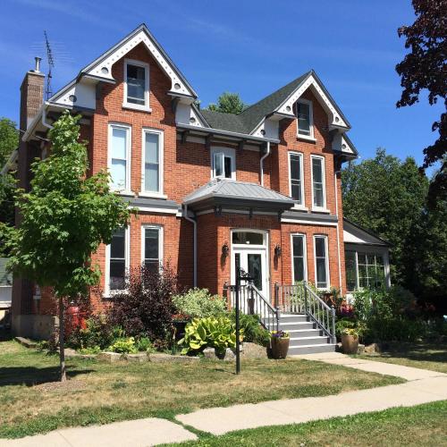 a red brick house with a white door at Seaway Manor B&B in Gananoque