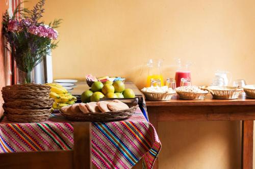 einen Tisch mit Obst und anderen Lebensmitteln darauf in der Unterkunft Hostal Qorichaska in Cusco