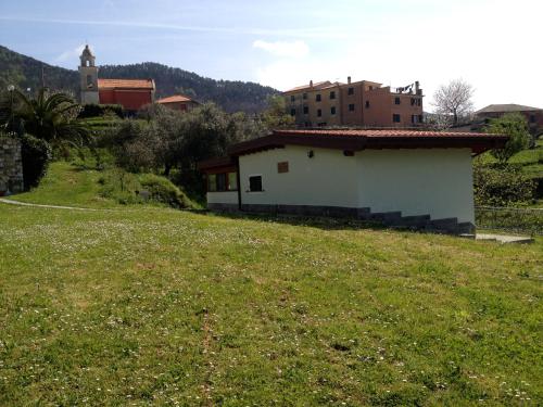 a small white building on a grassy hill at La Casa Di Menny Maison de Campagne in Moneglia