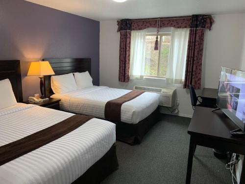 een hotelkamer met 2 bedden en een bureau bij Lake Country Inn in Winfield