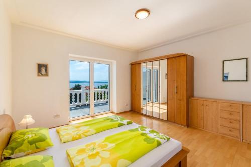 a bedroom with two beds and a large window at One-Bedroom Apartment in Crikvenica IX in Sopaljska