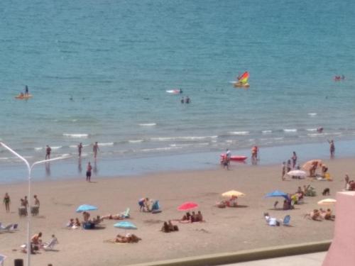 a group of people on a beach with umbrellas at Ventana al Mar in Puerto Madryn