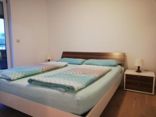 a bedroom with a bed with blue pillows on it at APARTMENT SCHLOSSBERGBLICK in Graz