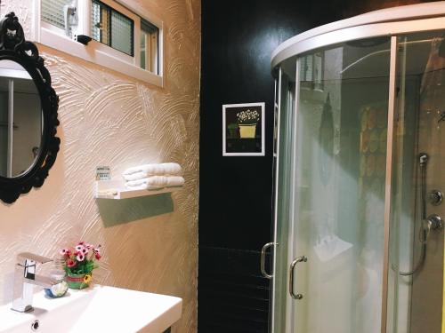 a bathroom with a shower and a sink and a mirror at Bambi斑比 in Tainan