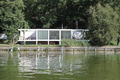 a house on a dock next to a body of water at Marina Hausboote und Seelodge in Berlin