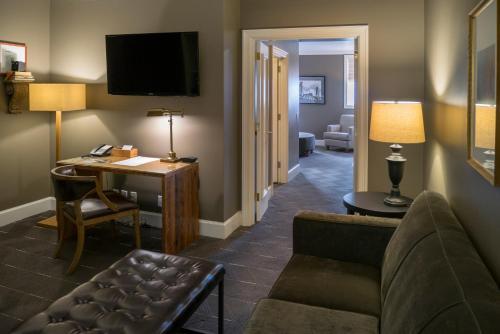 a living room with a couch and a desk in a room at Sentinel, a Provenance Hotel in Portland