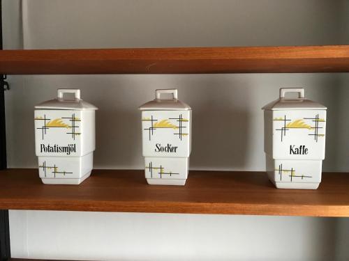 four water bottles sitting on a wooden shelf at Nina`s GuestHouse, Jämsä City, 160 m2, Include x2 Himos Ski Pass in Jämsä