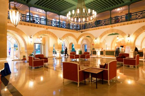 a lobby with a table and chairs and a chandelier at Regency Hotel & Spa in Monastir