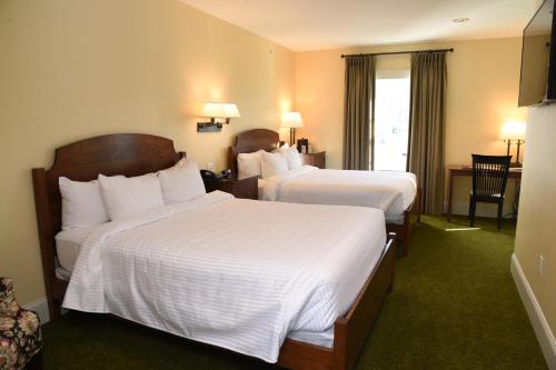a hotel room with two beds with white sheets at Publick House Historic Inn and Country Motor Lodge in Sturbridge