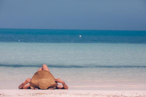 a person laying on the beach in the water at Tintipan Cabana SalSiPuedes in Tintipan Island