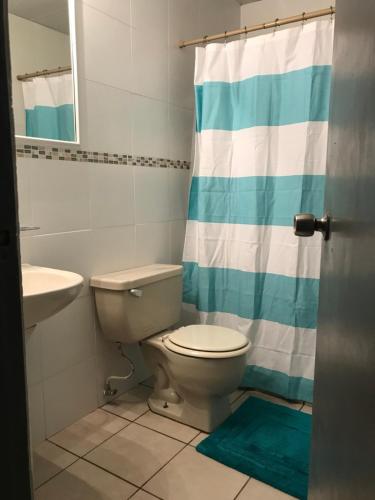 a bathroom with a toilet and a sink at Urban Terrace Apartment in San Juan in San Juan