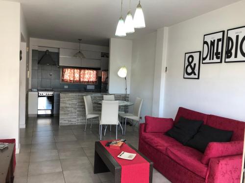 een woonkamer met een rode bank en een tafel bij Rent Apart Caballito in Buenos Aires