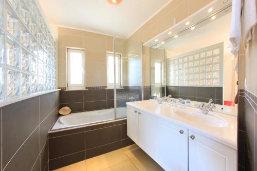 a bathroom with two sinks and a tub and a shower at Villa Lena in Pakoštane