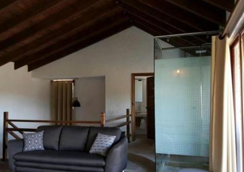 a living room with a couch and a glass shower at La Mora Casa de Campo in Huasca de Ocampo