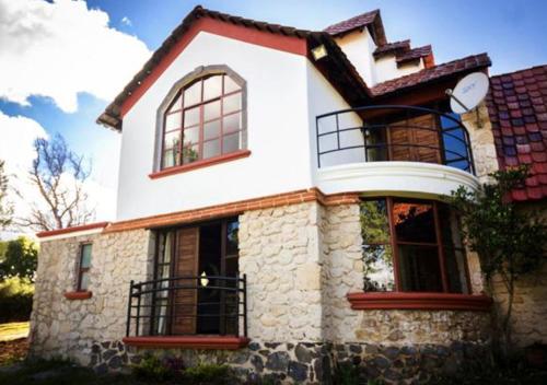a white house with windows and a roof at La Mora Casa de Campo in Huasca de Ocampo