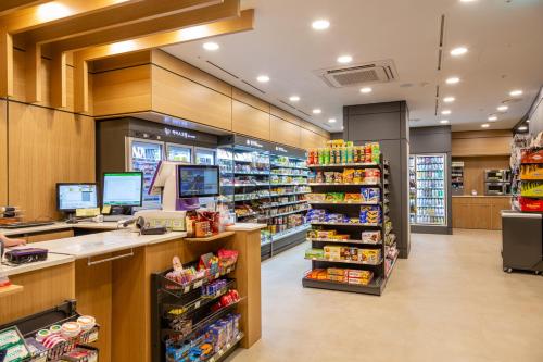 a grocery store aisle with a cash register and a supermarket at Grand Walkerhill Seoul in Seoul