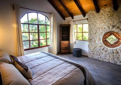 a bedroom with a large bed and a mirror at La Mora Casa de Campo in Huasca de Ocampo