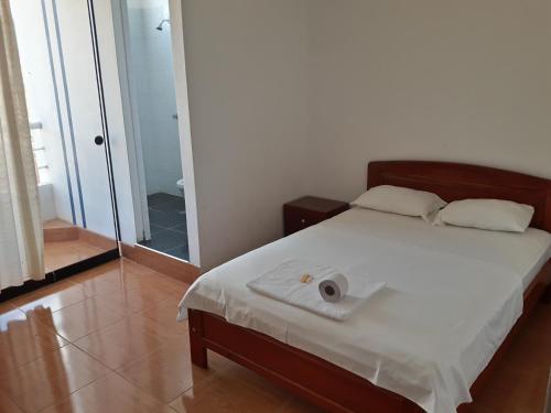Un dormitorio con una cama con una toalla. en Hotel Santorini, en Jaén