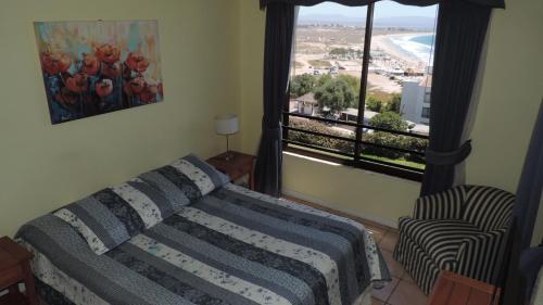 a bedroom with a bed and a window with a view at Departamento Puerto Velero in Puerto Velero