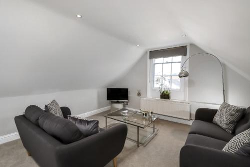 a living room with two couches and a table at Gorgeous Apartment in the centre of Winchester in Winchester
