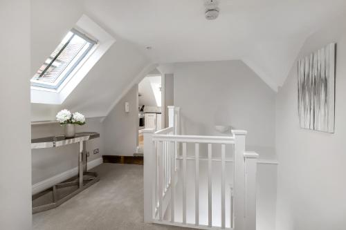 a white staircase in a white room with a window at Gorgeous Apartment in the centre of Winchester in Winchester