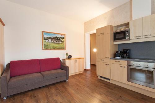 a living room with a couch and a kitchen at ALPENAPART LADIS ehemals Alpenapart Alexander in Ladis