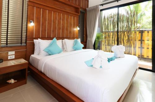 a bedroom with a large white bed with teddy bears on it at The Scene Cliff View Villas in Ao Nang Beach