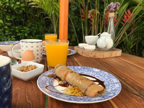 a table with a plate of breakfast food and drinks at Ganso & Búho in Ayampe