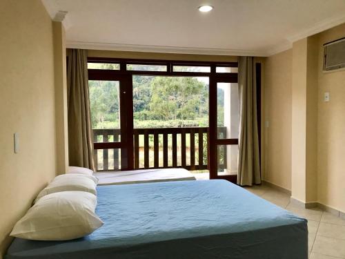1 Schlafzimmer mit 2 Betten und einem großen Fenster in der Unterkunft Ecopousada Garten Haus in Santa Teresa