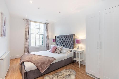 een slaapkamer met een bed en een raam bij Knightsbridge Dream Apartment in Londen