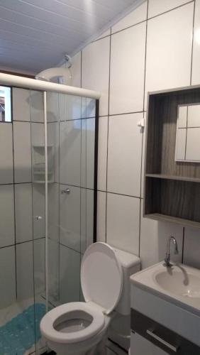 a bathroom with a toilet and a shower and a sink at Espaço Elza Izabel in Piçarras