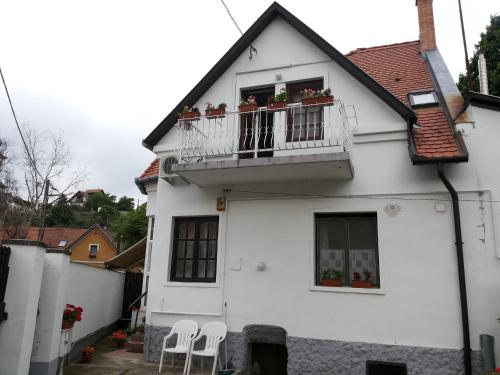a white house with a balcony with white chairs at Valentin ház in Szentendre