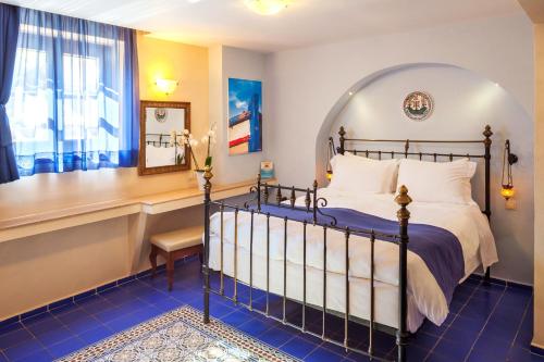 a bedroom with a bed and a desk and a window at In Camera Art Boutique Hotel in Rhodes Town