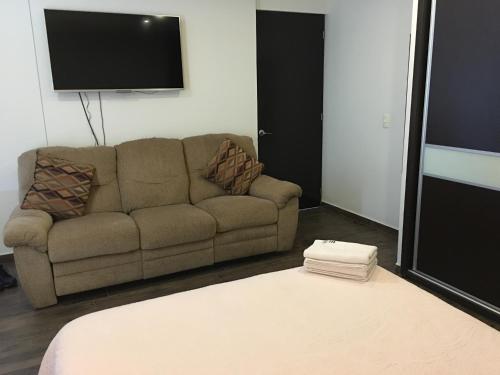a living room with a couch and a flat screen tv at Residencial WTC Suites México in Mexico City