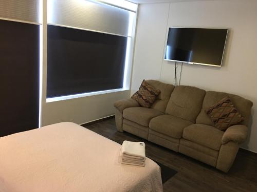 a living room with a couch and a flat screen tv at Residencial WTC Suites México in Mexico City