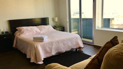a bedroom with a bed with a pink blanket and a window at Residencial WTC Suites México in Mexico City