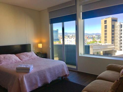a bedroom with a bed and a large window at Residencial WTC Suites México in Mexico City