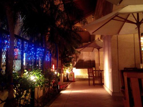a patio at night with blue lights on a building at Hotel Sun Queen in Naha