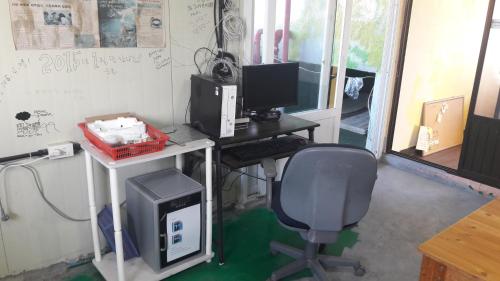 an office with a desk with a computer and a chair at Minjoonggak in Seogwipo