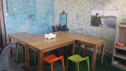 a wooden table with colorful chairs in a room at Minjoonggak in Seogwipo