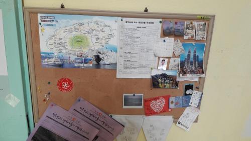 a bulletin board with a map and posters on it at Minjoonggak in Seogwipo
