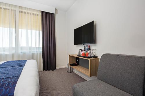 a hotel room with a bed and a flat screen tv at Mantra MacArthur Hotel in Canberra