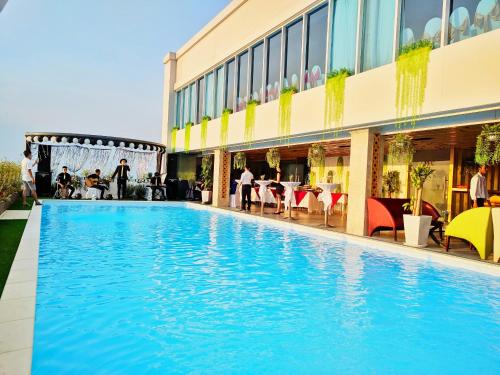 a large swimming pool in front of a building at Holiday One Can Tho Hotel in Can Tho