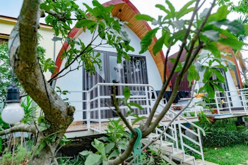 a house with a porch and a tree at Areca Bungalow in Phong Nha