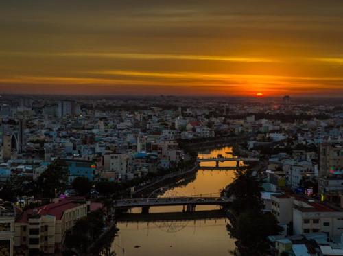 a sunset over a city with a river and a bridge at Holiday One Can Tho Hotel in Can Tho