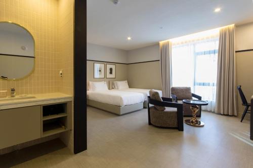 a hotel room with a bed and a sink and a mirror at Browndot Business Seomyeon in Busan
