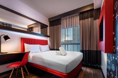 a hotel room with a bed and a desk and a chair at Essence Hotel Carlton in Melbourne
