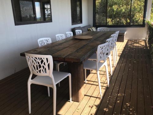 a wooden table and chairs on a deck at Fareview Beach House in Emu Bay