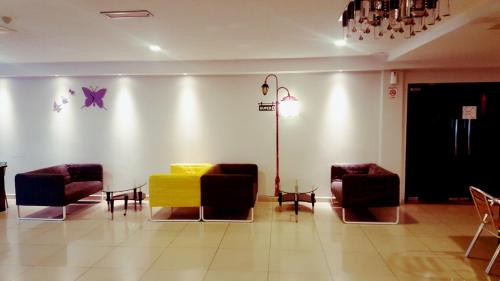 a waiting room with a yellow couch and chairs at Super 8 Hotel @ Georgetown in George Town
