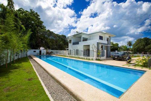 a swimming pool in front of a house at 1949 Dreamy Home in Panglao